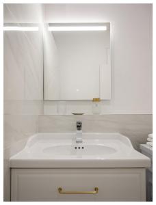 Un baño blanco con lavabo y espejo. en Joli studio face au Pavillon Baltard, en Nogent-sur-Marne 23 fotos más