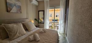 ein Schlafzimmer mit einem weißen Bett mit Handtüchern darauf in der Unterkunft Casa de las Olas in Torremolinos