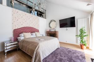 a bedroom with a large bed and a tv at Wellness & SPA boutique Hotel pod lipkami Prague in Prague