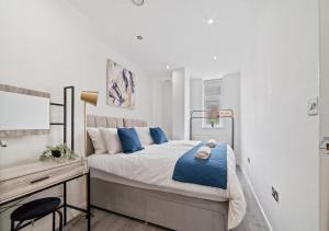 a bedroom with a bed with blue pillows and a desk at The Sapphire Suite - 2BR 2Bath City Centre in Leicester