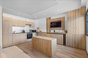 a large kitchen with wooden cabinets and a table at La Capsule - Studio avec vue panoramique in Sion