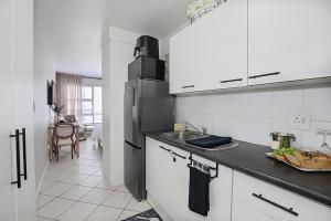 a kitchen with a sink and a refrigerator at Seehuys Beachfront Studio Sea & Mountain Views in Bloubergstrand