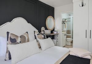 a bedroom with a white bed and a mirror at Seehuys Beachfront Studio Sea & Mountain Views in Bloubergstrand