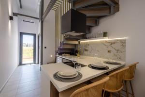 a kitchen with a table with plates and glasses on it at White Pampas Tiny houses in Paralia Dionysiou