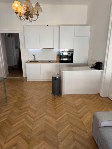 a kitchen with white cabinets and a wooden floor at Marschall 8 in Graz