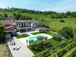 una imagen de una villa con piscina en un viñedo en B&b La Creusa, en Calosso