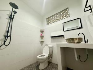 een witte badkamer met een toilet en een wastafel bij Oh Town Villa in Thongsala