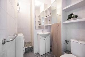 a white bathroom with a sink and a toilet at Apartament Centrum in Warsaw +49 photos