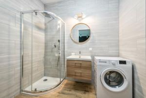 a bathroom with a washing machine and a shower at Plac Unii by NorthSide Apartments in Gdynia +31 photos