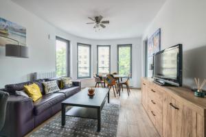 a living room with a couch and a tv at Plac Unii by NorthSide Apartments in Gdynia
