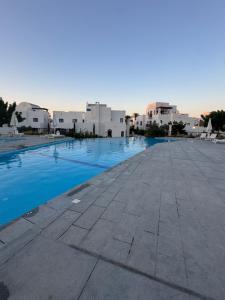 a swimming pool with white buildings in the background at Marassi El Alamein Luxury Villa مراسي العلمين in El Alamein