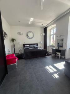 a large bedroom with a bed and a red chair at I'M Apartment PLATINUM premium in Bolesławiec