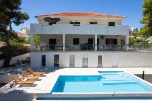 a house with a swimming pool in front of a house at Villa Rosea in Slatine