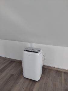 a white trash can sitting in the corner of a room at MM House in Relógio do Poiso