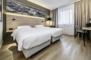 a hotel room with a large bed and a desk at Park Inn by Radisson Vilnius Airport Hotel & Conference Centre in Vilnius