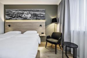 a hotel room with a bed and a chair at Park Inn by Radisson Vilnius Airport Hotel & Conference Centre in Vilnius