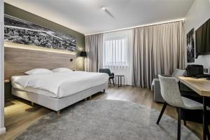 a hotel room with a bed and a desk at Park Inn by Radisson Vilnius Airport Hotel & Conference Centre in Vilnius