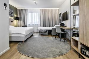 a hotel room with two beds and a desk at Park Inn by Radisson Vilnius Airport Hotel & Conference Centre in Vilnius