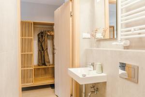 un bagno bianco con lavandino e specchio di Kątowa Studio - Sauna, AC, balcony a Cracovia