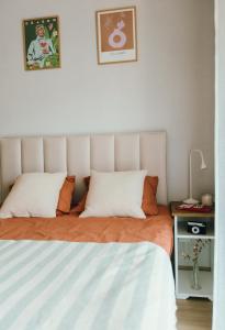 una camera da letto con un letto con lenzuola arancioni e bianche di Kątowa Studio - Sauna, AC, balcony a Cracovia