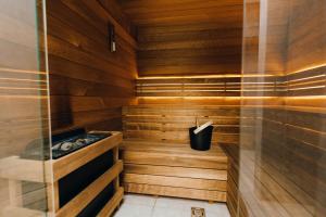 a sauna with wood paneling and a black bucket at Kątowa Studio - Sauna, AC, balcony in Krakow
