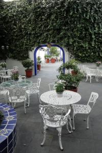 a patio area with tables, chairs, tables and umbrellas at Hotel Casa Gonzalez in Mexico City