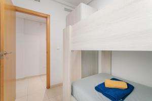 a bedroom with a bed with a yellow pillow on it at Entre Castillo y Mar in Santa Pola