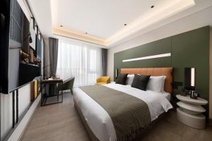 Ένα ή περισσότερα κρεβάτια σε δωμάτιο στο Shanghai Jiading New Town Suisse Place Apartment Hotel