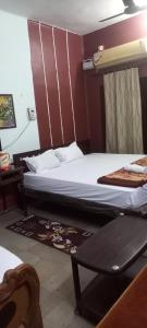 a hotel room with two beds and a table at THUBE Saheb B&B in Jabalpur +29 photos