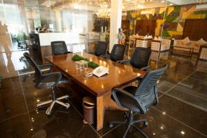 DaulatābādにあるHotel Grand Sarowar and Shakuntal Lawnsの木製のテーブルと椅子のある会議室