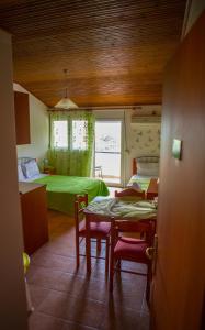 Cette chambre comprend un lit, une table et des chaises. dans l'établissement Drosia Hotel, à Kato Loutraki