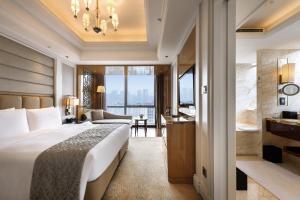 a hotel room with a bed and a living room at The Ritz-Carlton, Chengdu in Chengdu
