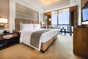 a hotel room with a large bed and a television at The Ritz-Carlton, Chengdu in Chengdu