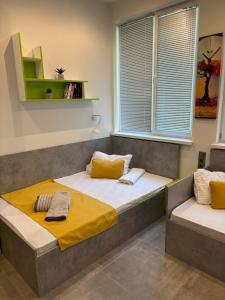 a bedroom with a bed with a yellow blanket at DORM BG pet-friendly Aparthotel in Stara Zagora