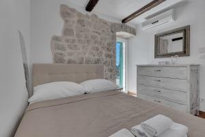 a bedroom with a large bed and a stone wall at Stonehouse Villa Luma - Makarska Exklusiv in Bast +30 photos