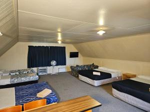 a room with three beds and a tv in it at Bulls Motel & Holiday Park in Bulls