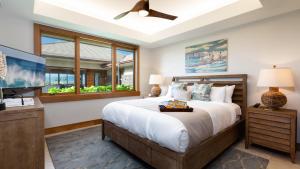 ワイコロアにあるELEGANT ESCAPE Elegant 4BR Laulea Home with Pool and Ocean Viewのベッドルーム1室(大型ベッド1台、シーリングファン付) +77枚の写真