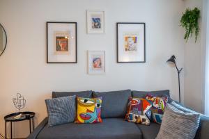 a living room with a blue couch with pillows at Special TRIO PICASSO Apartment Basel, Bahnhof Grossbasel 10-STAR in Basel