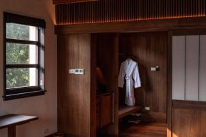 een kleedkamer met een badjas aan een deur bij Hangzhou West Lake Anyu Hotel in Hangzhou +94 foto's