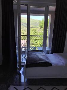 a bedroom with a bed and a view of a balcony at TriM Apartments in Travnik