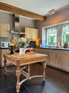 a kitchen with a wooden table with flowers on it at La Belly d'or in Izier