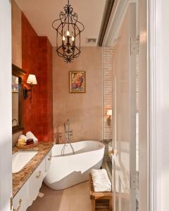 a bathroom with a large tub and a chandelier at The Luna Boutique Hotel in Quy Nhon +39 photos