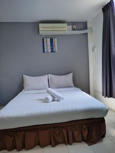 a bed with a white object on top of it at Hotel Seroja in Labuan