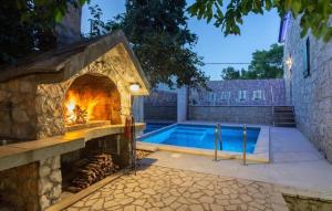 a stone fireplace next to a swimming pool at MSV Modern Stone Villa in Imotski