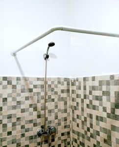 a shower in a bathroom with a tiled wall at Ennakhail apart in Marrakech