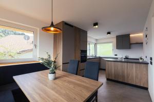 a kitchen and dining room with a wooden table in a room at Alpenglow Apartments in Collalbo