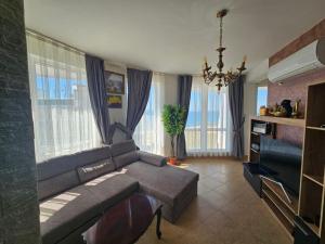a living room with a couch and a television at Aparthotel Costa Calma in Aheloy