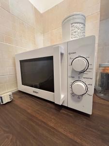 a microwave oven sitting on top of a counter at A C Tourist Accommodation in Torvaianica