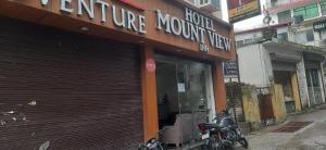 a store front of a store with a motorcycle parked outside at Hotel Mount view inn in Rishīkesh