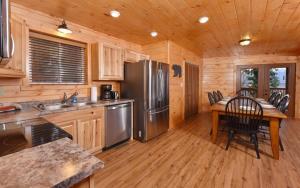 a kitchen with a stainless steel refrigerator and a table at Bearfoot Lodge in Gatlinburg
